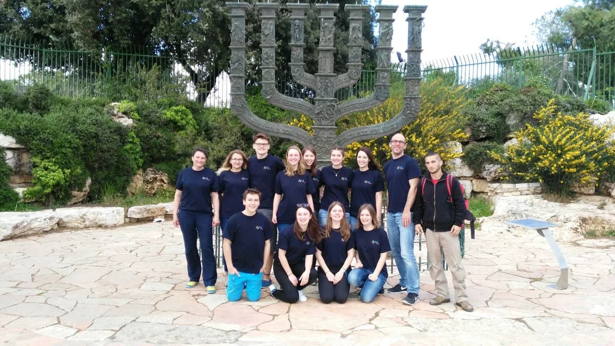 Eine Gruppe der Jugendbegegnung mit Israel steht vor einem großen Chanukka-Leuchter