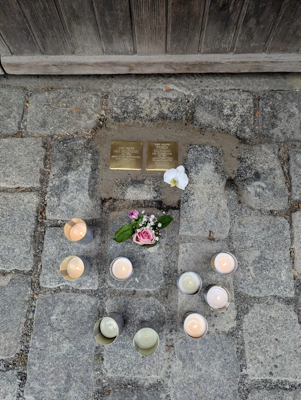 Zwei der neu verlegten Stolpersteine in Zeil am Main, mit Kerzen und Blumen.