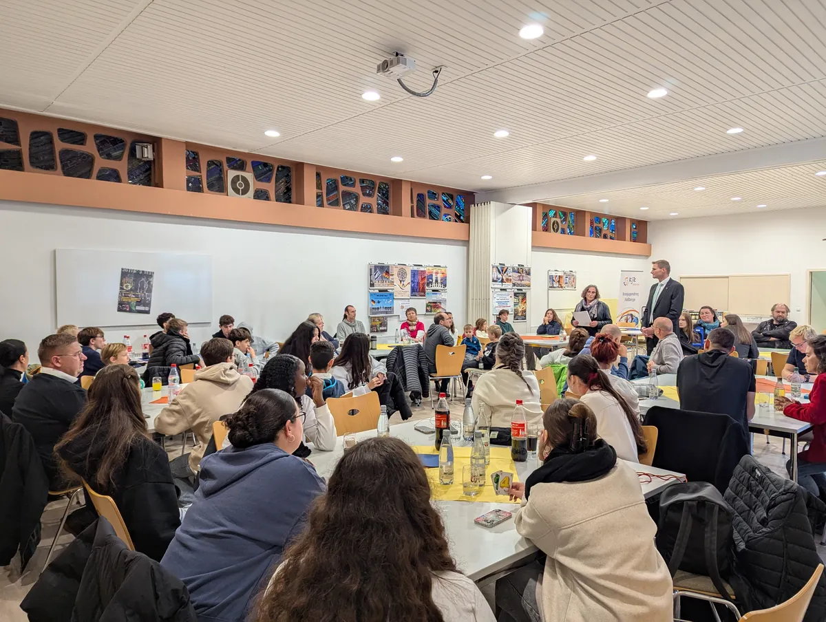 Die Gastfamilien und die deutsch-israelische Gruppe hören im Pfarrsaal in Zeil am Main den Grußworten von Susanne Makowski (KJR-Vorsitzende) und Marcus Fröhlich (2. Bürgermeister der Stadt Zeil und Geschäftsführer Landratsamt Haßberge) zu.