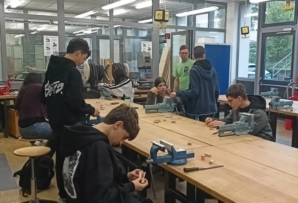 Im Werkraum der Mittelschule Haßfurt bearbeitem Jugendliche am Schraubstock Holz.