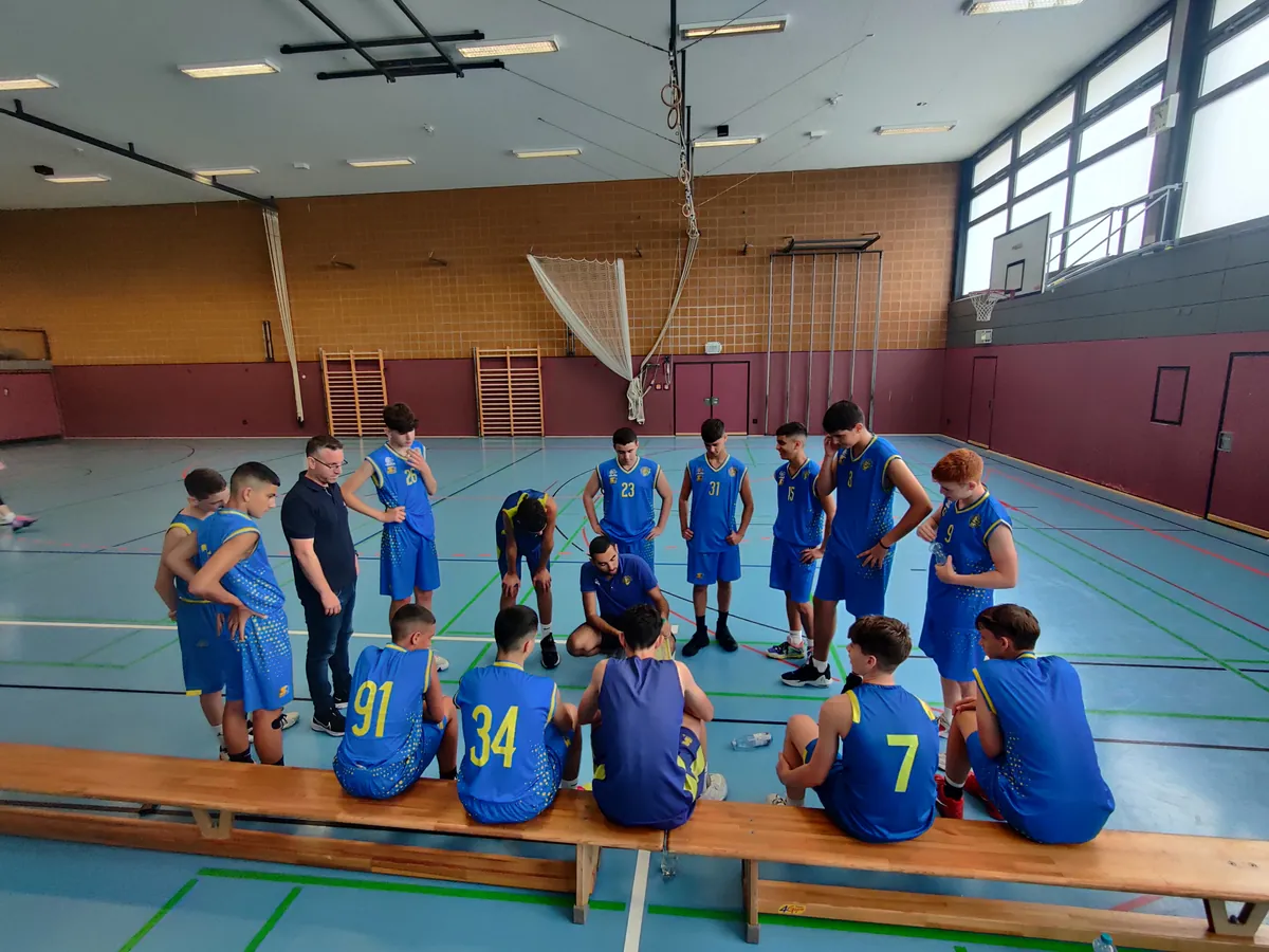 Eine Mannschaft jugendlicher Basketballspieler stehen im Kreis