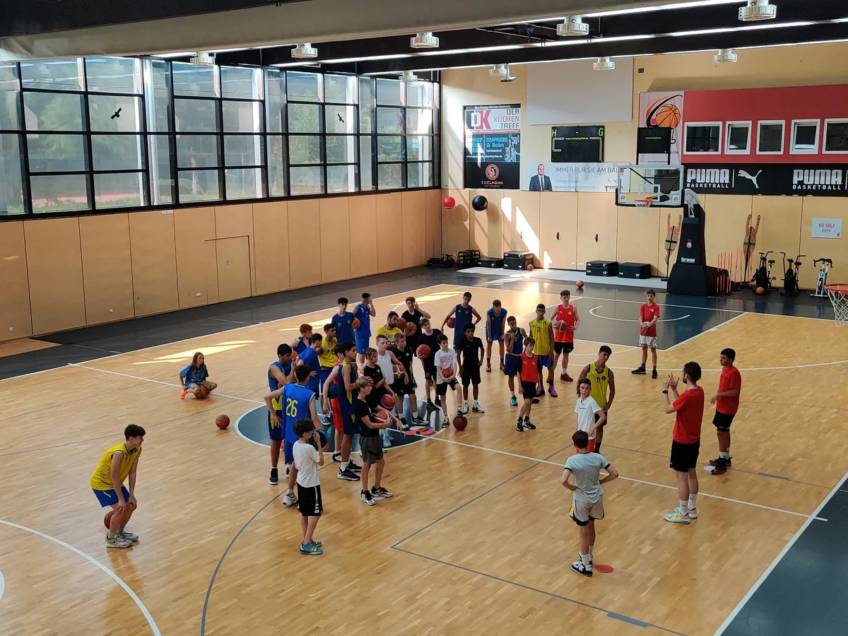 Jugendliche in einer Halle beim Basketballtraining