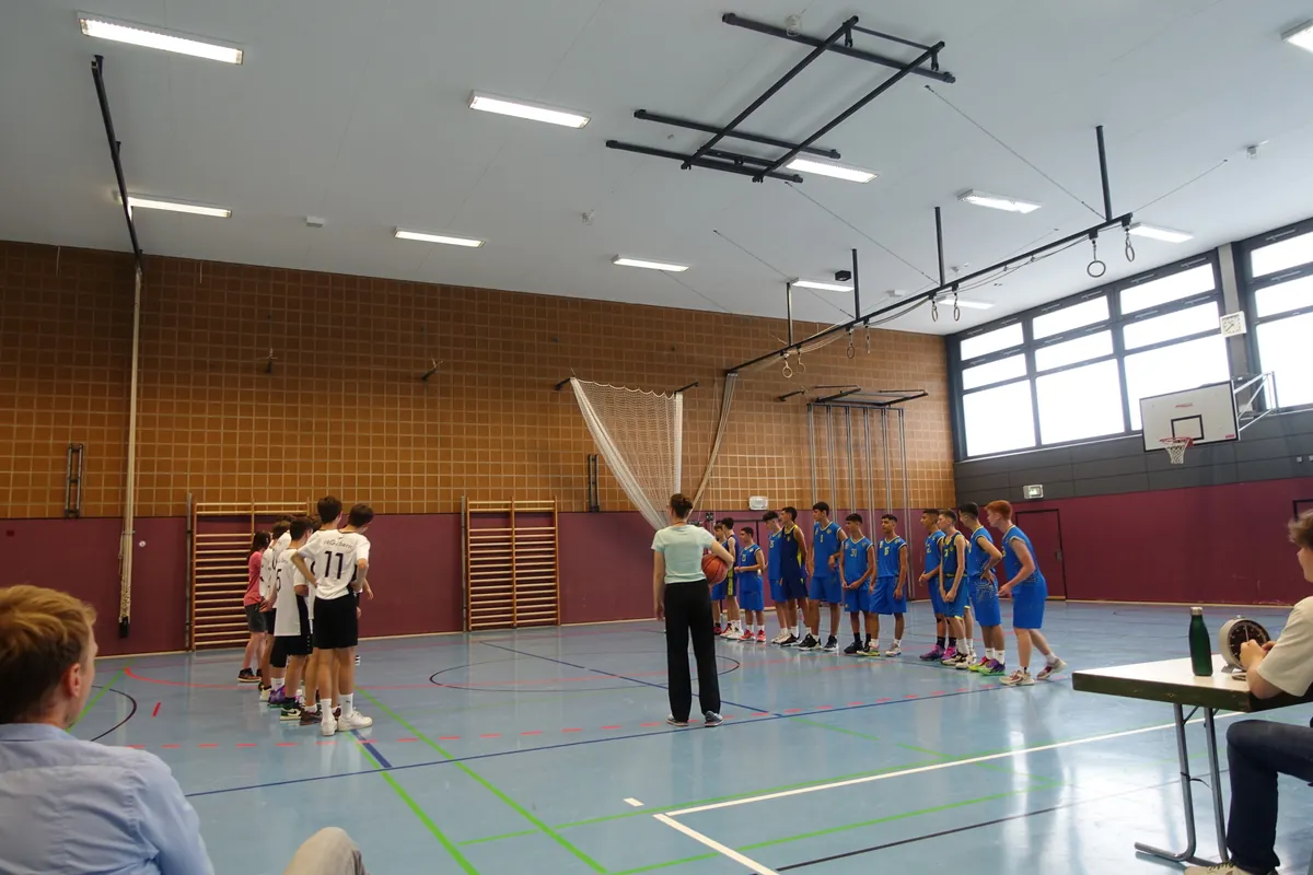 Zwei Basketballmannschaften stehen sich in Reihen gegenüber