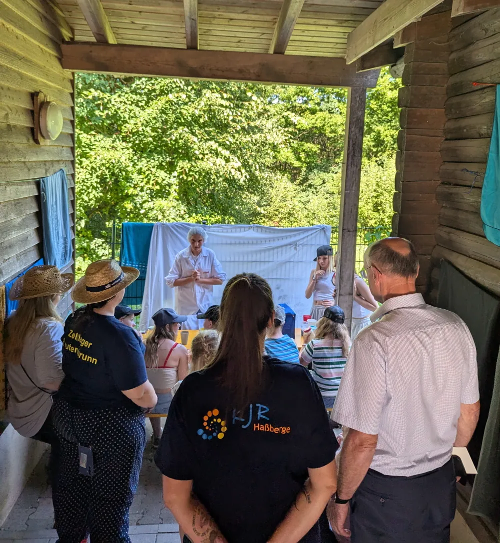Landrat Wilhelm Schneider und Petra Erickson schauen der Mädelsgruppe an der "Milchtasting"-Station zu.