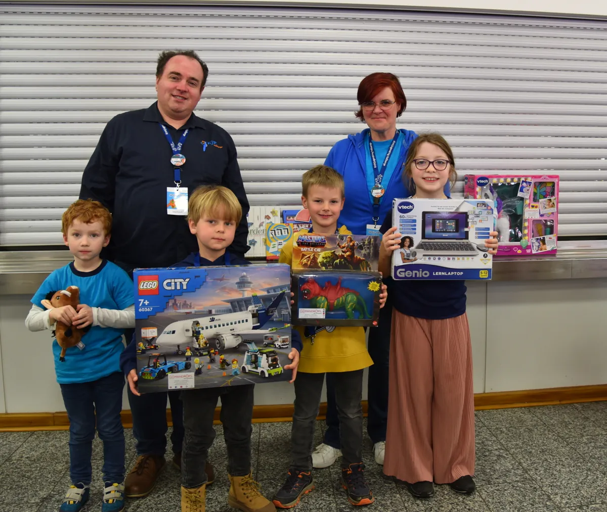 Spieletage-Leitung Wolfgang Winter, Turnier-Leitung Tamara Gräb und die Gewinner des Kinderspiel des Jahres Turnier mit ihren Gewinnen Lego-Flugzeug, Lern-Laptop und Spielzeug-Dinosaurier