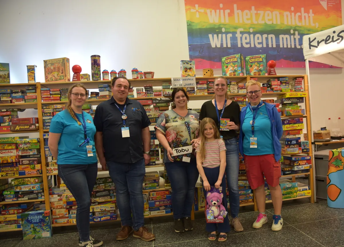 Spieletage-Leitung Wolfgang Winter, Turnier-Leitungen Julia Dinkel und Elisabeth Dürr mit den Gewinnern des Kniffel-Turniers mit ihren Gewinnen "Tabu"-Spiel, "Lama"-Spiel und rosa Teddybär