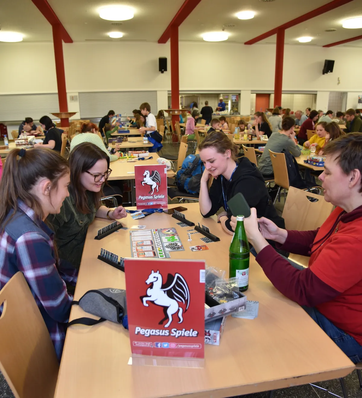 Spielerklärerin vom Pegasus Spielverlag erklärt 3 Personen ein Spiel